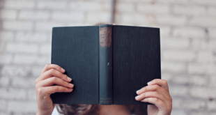 Person holding a book in front of their face